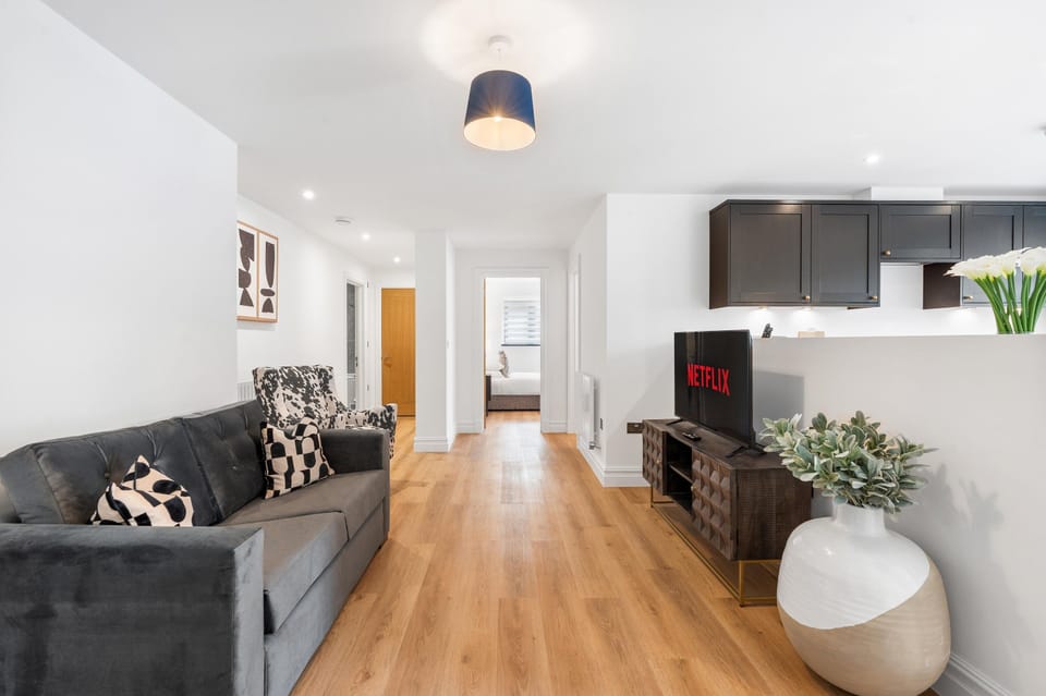 Bright open-plan living room with comfortable seating, Smart TV and a modern coastal-inspired interior.