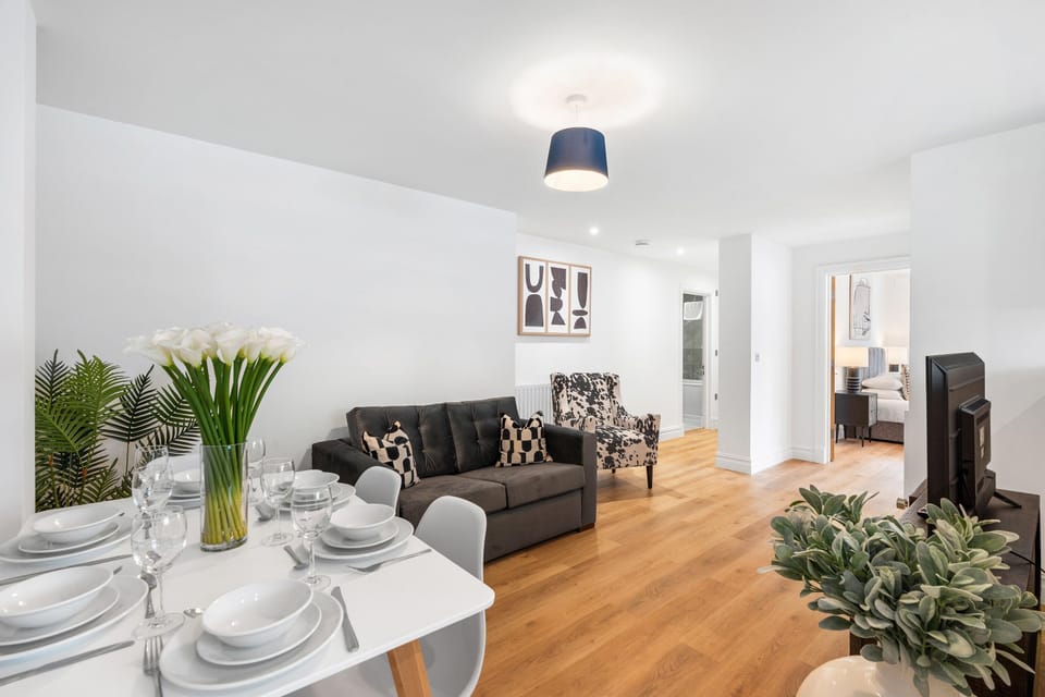 Bright open-plan living room with comfortable seating, Smart TV and a modern coastal-inspired interior.