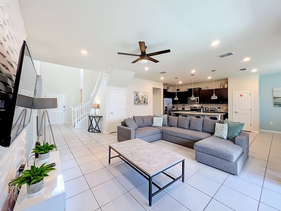 Spacious living area with a large sectional sofa, and a TV