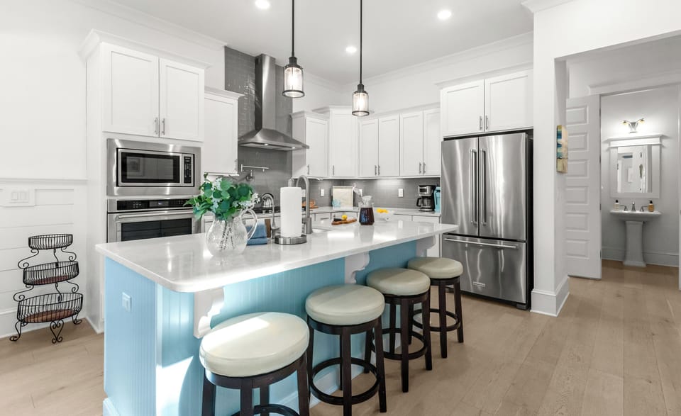 Picture yourself preparing meals in this modern kitchen with its spacious island, stainless steel appliances, and stylish seating.