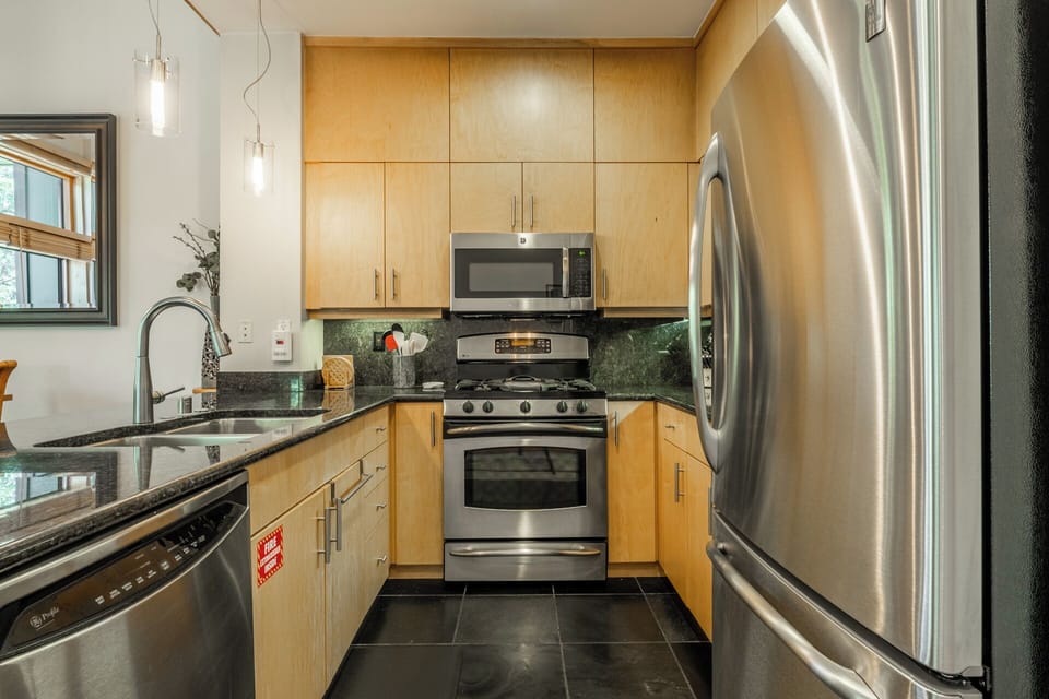 Your well-appointed kitchen features modern stainless steel appliances, beautiful maple cabinetry, sleek granite countertops, and everything you need to prepare delicious home-cooked meals during your stay.