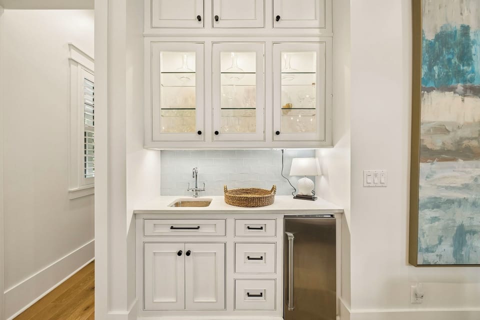 Your convenient wet bar features elegant glass-front cabinetry, a sleek sink, and an under-counter beverage fridge—perfect for entertaining or enjoying a quiet evening in.