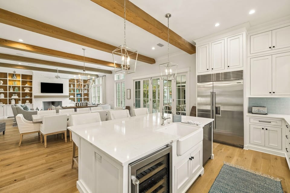 Step into your bright, open-concept kitchen and dining area, where exposed wood beams and elegant pendant lighting create a warm, inviting space perfect for gathering with family and friends.
