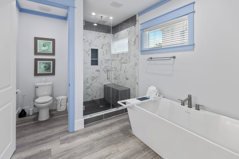 Indulge in your private spa-like retreat with a modern soaking tub and elegant marble-tiled walk-in shower, thoughtfully designed for your comfort.