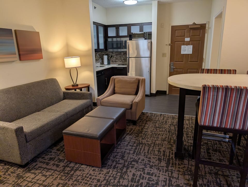 Spacious living area with sofa seating and dining table.