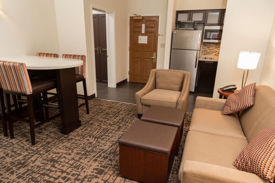 Comfortable living area with decorative pillows and kitchen access.