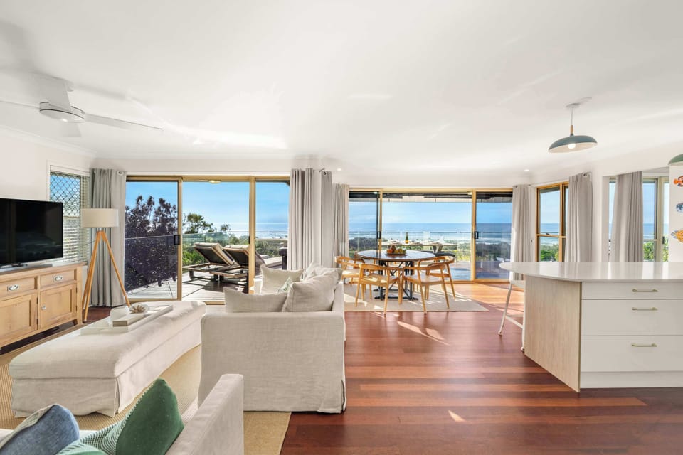 Relax in a light-filled living space where comfortable seating and expansive glazing invite the coastal outlook inside.