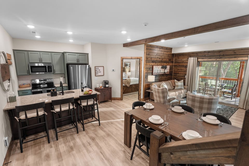 Walk in the front door to gather in the open great room where kitchen, dining, and living flow together under wood-beam ceilings.