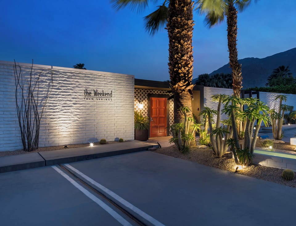 Elegant twilight view of the property's secure front entrance and illuminated signage.