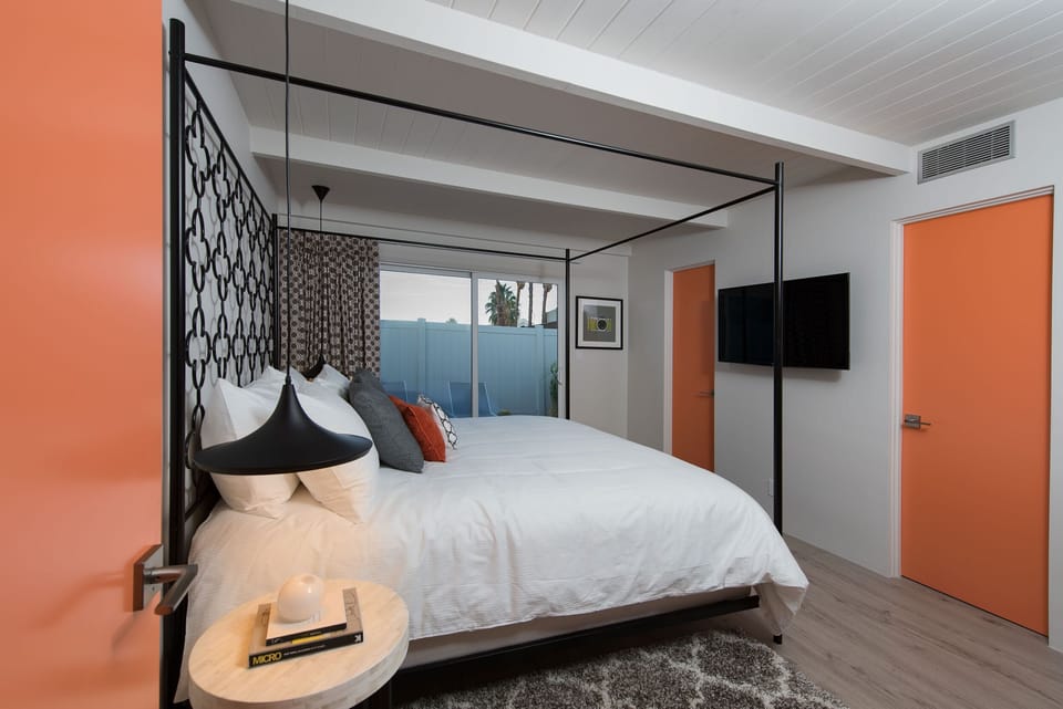 Sophisticated master bedroom showcasing a dramatic black canopy bed and minimalist luxury design.