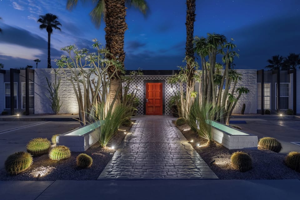Dramatic evening view of the beautifully illuminated main pathway and architectural desert plants.