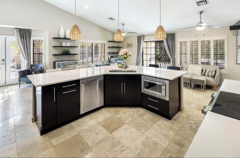 Bright open kitchen with island seating, pendant lighting, and easy flow to the living area.