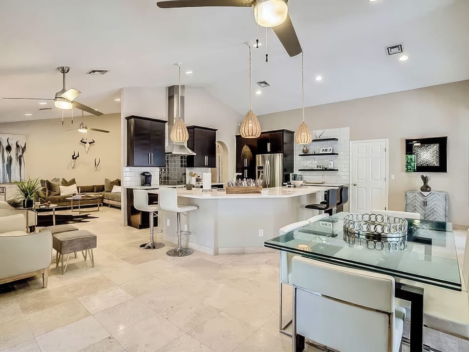 Open-concept living, dining, and kitchen area with bar seating, modern finishes, and a bright airy feel.