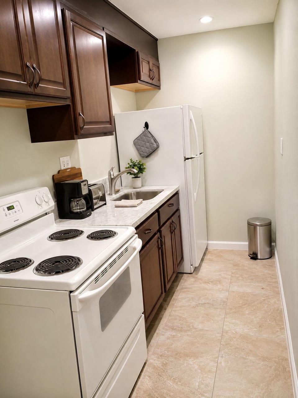 Bright galley kitchen with full-size appliances and warm wood cabinets