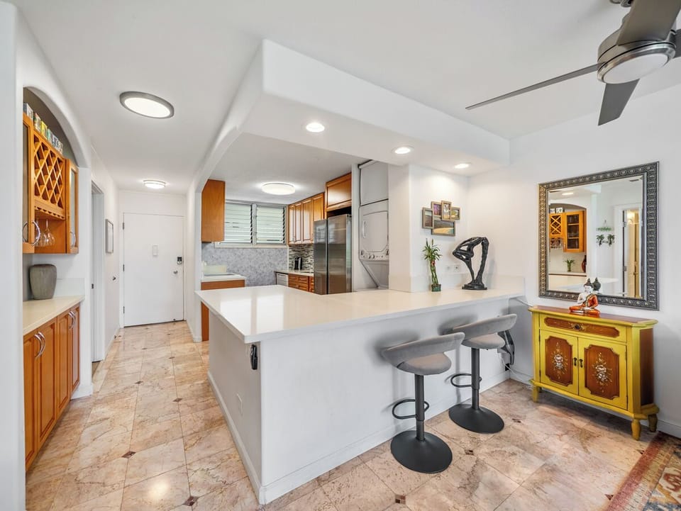 Kitchen - Gather around the spacious breakfast bar in Harbor View Plaza's full kitchen, with seating for three and an in-unit washer and dryer adding valuable convenience to a monthly Waikiki stay.