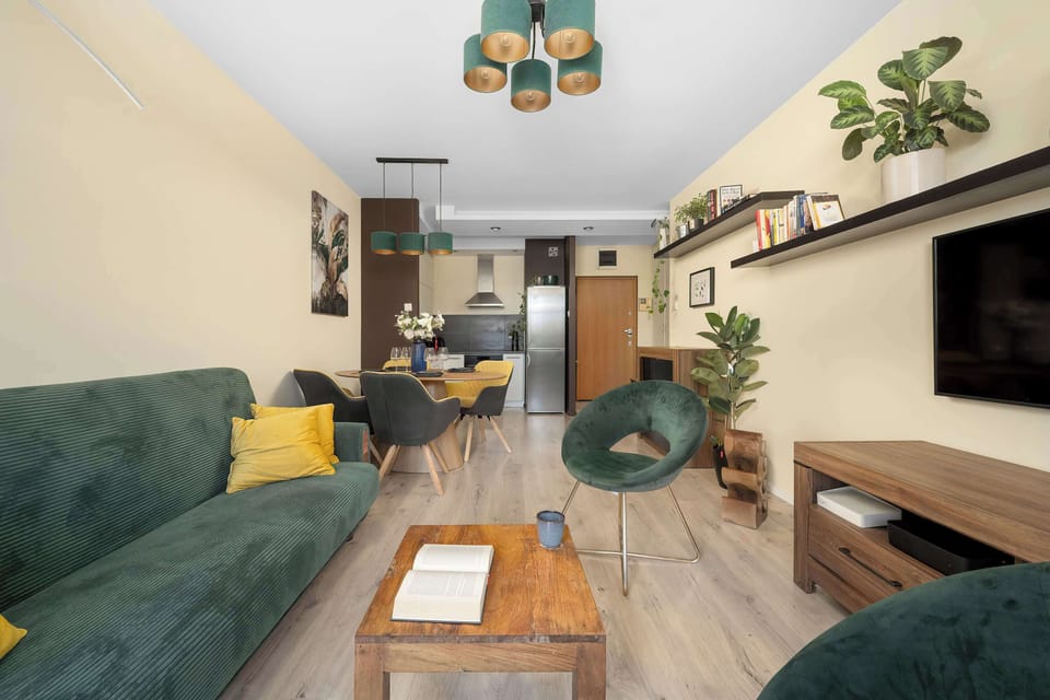 Spacious living area with a sofa, coffee table, TV, and open-plan layout.