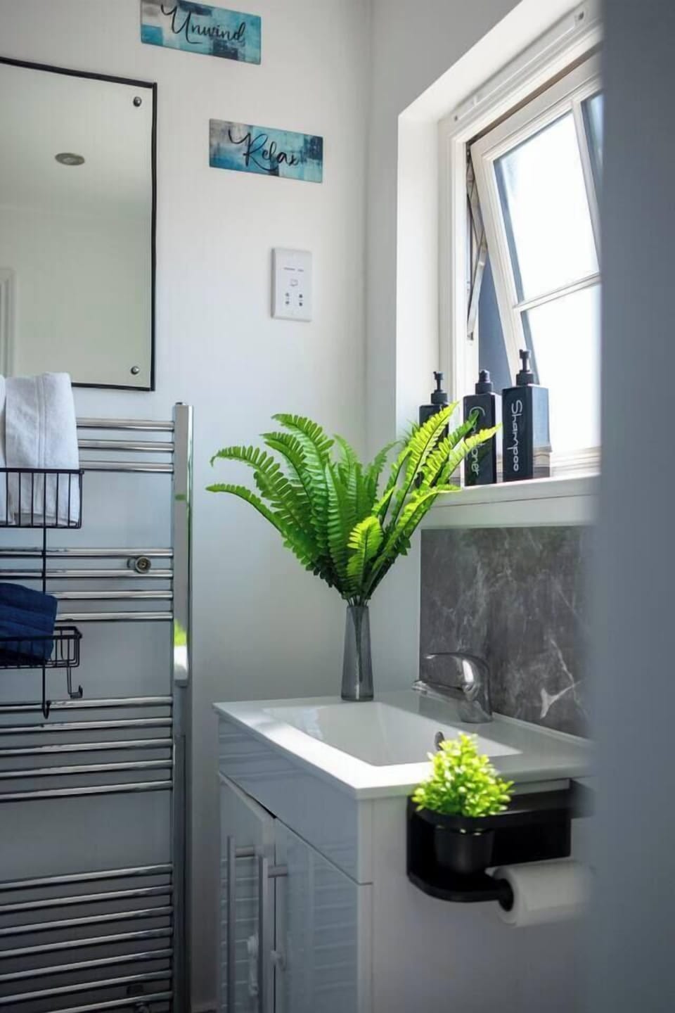 Bright spa-like bathroom with natural light, sleek vanity, and modern touches