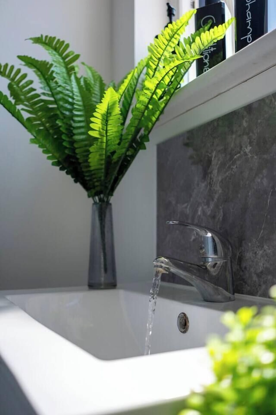 Bright, spa-like bathroom with modern finishes and fresh greenery