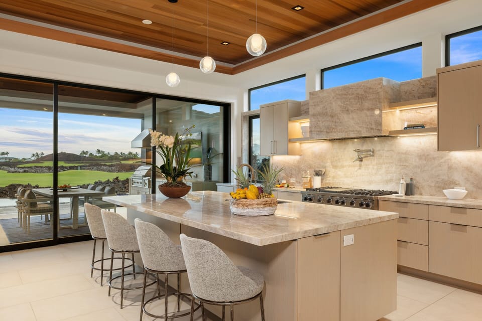 The oversized island naturally becomes the day's meeting place, from morning coffee to evening cocktails.