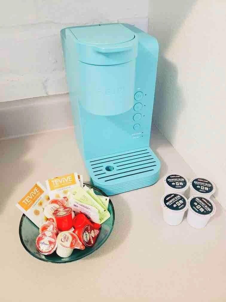 Keurig with complimentary K-cups, creamer, sugar and tea.