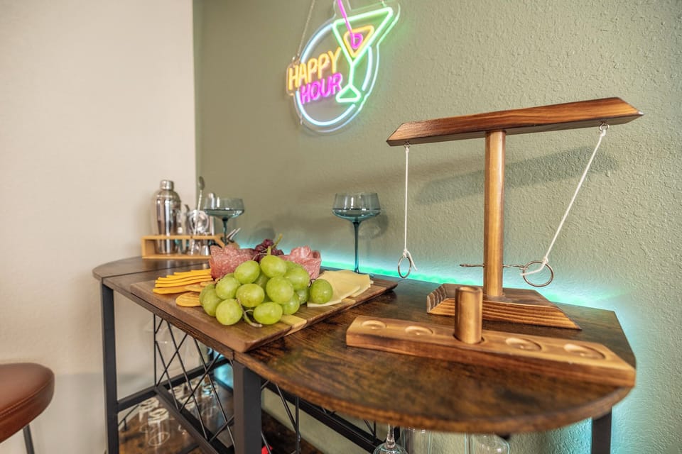 Happy hour HQ — the neon-lit bar nook with ring toss on the wall. BYO fav B
