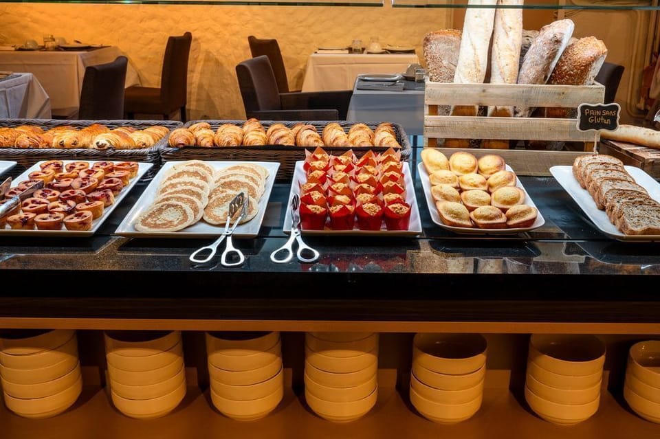 A generous selection of breads and pastries is part of the daily breakfast offering, available each morning for guests at an additional charge.