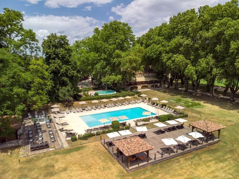 The outdoor pool sits at the centre of a 7-hectare landscaped park, where sun loungers and shaded terraces invite guests to unwind between explorations of the Luberon.