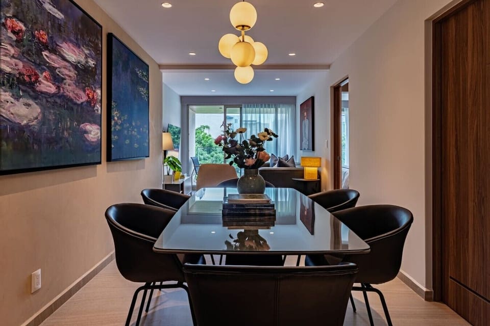 Enjoy meals and conversations in the elegant dining area, featuring contemporary artwork.