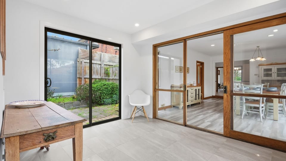 Large glass doors create a seamless connection between the indoor living space and the private garden.