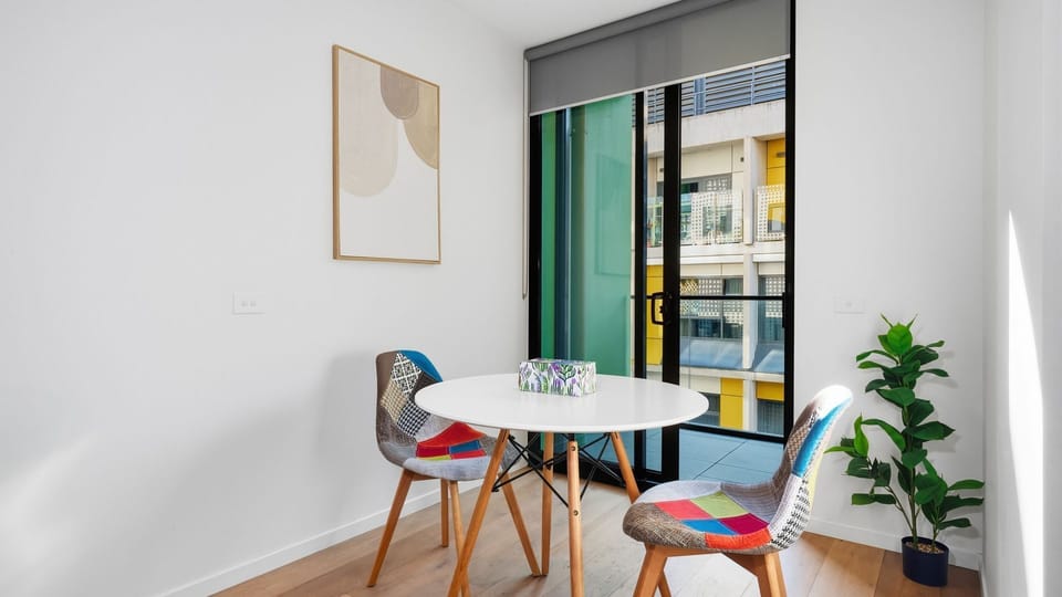 Floor-to-ceiling balcony doors invite natural light into the dining area throughout the day.