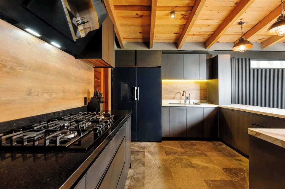 Sleek matte-black cabinetry and full-size appliances outfit this chef-ready kitchen.