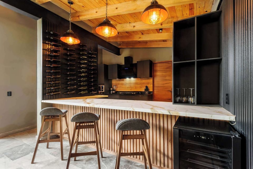 A moody, gallery-style wine wall and marble bar turn the kitchen into the heart of every gathering.