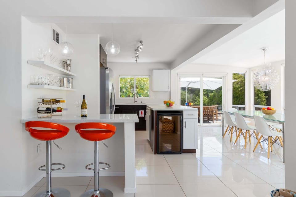 Kitchen is equipped with stainless steel appliances, counter seating for 2, wine fridge, and a spacious kitchen island.