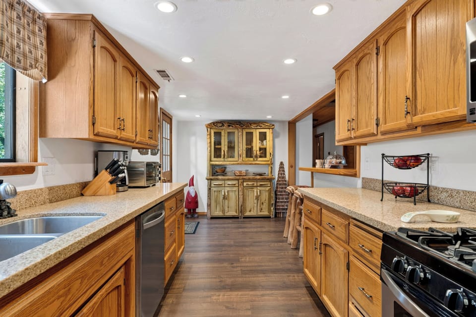 Galley-style kitchen offering extensive counter space, custom wooden cabinetry, and plenty of storage.