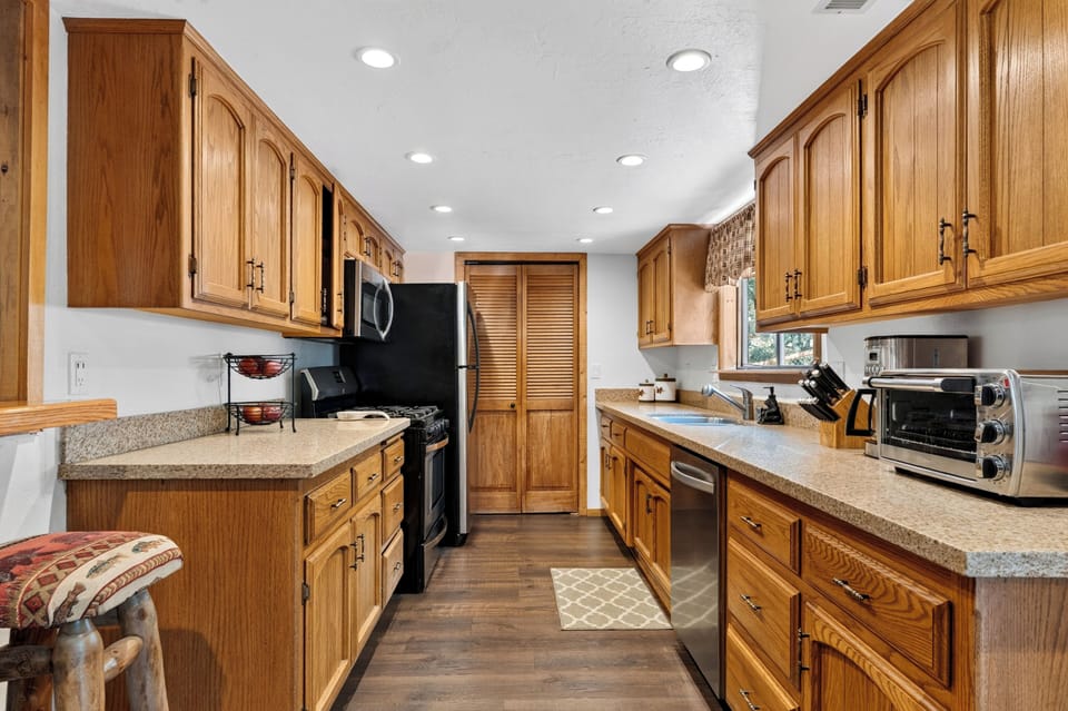 Bright kitchen view showcasing the clean layout, built-in microwave, and direct access to the rest of the main floor.