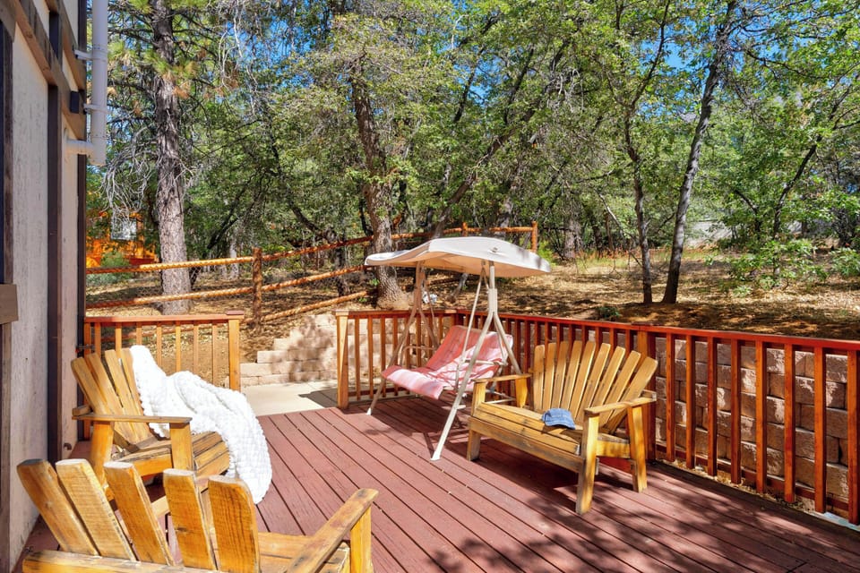 Sunny deck space featuring comfortable wooden lounge seating and an outdoor swing bench.