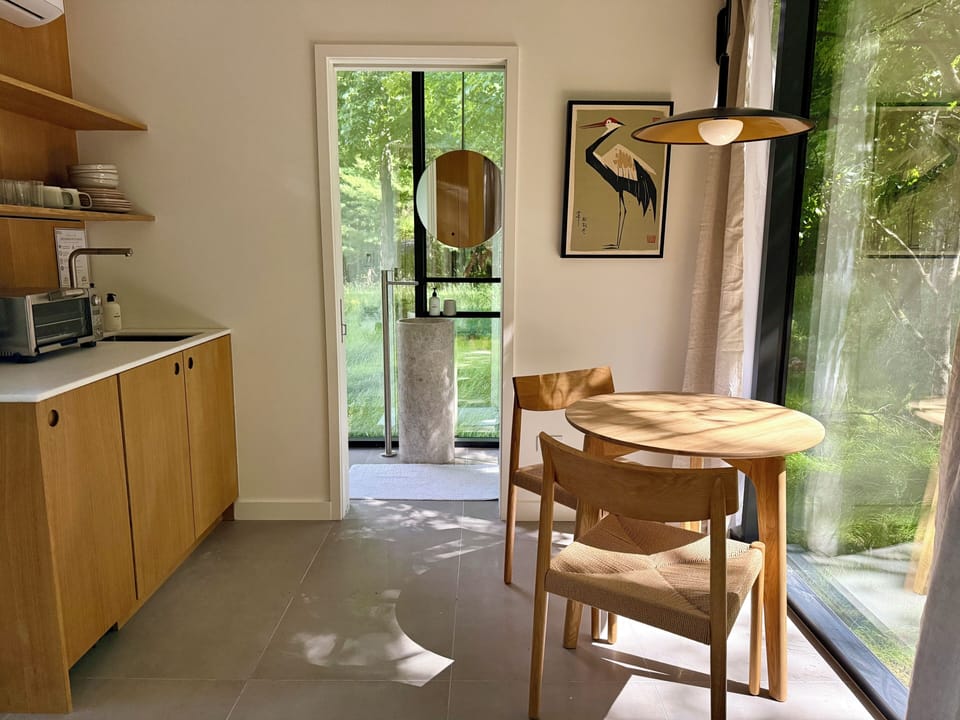 Sunlit dining nook with a round oak table and a signature heron print.