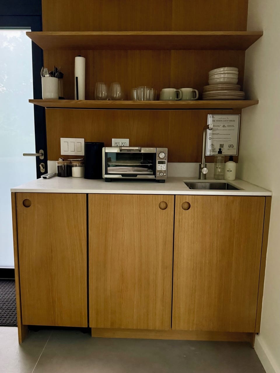 The guest house kitchenette, compact and fully appointed in white oak.