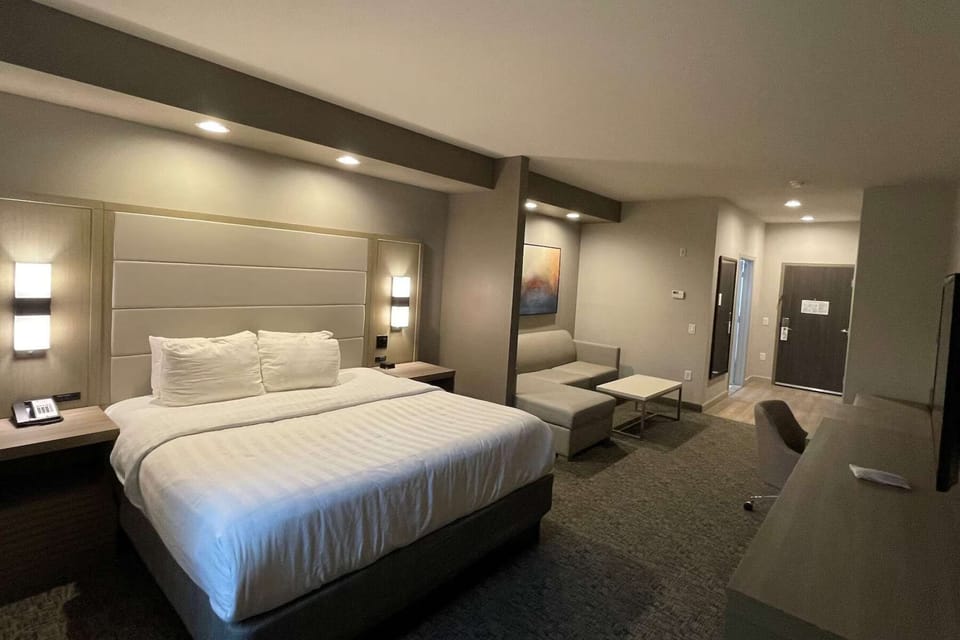 Spacious suite with king bed, sofa, and workspace