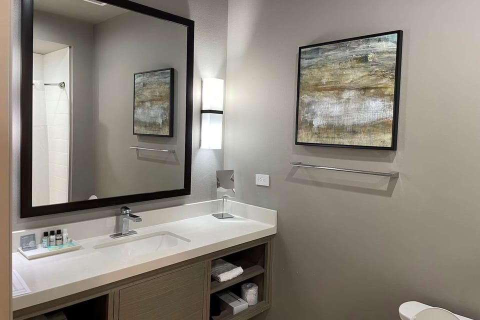 Bathroom with framed mirror, sink, and amenities