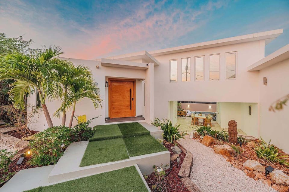 A warm wooden entrance and landscaped pathway welcome you home after a full day exploring Aruba.