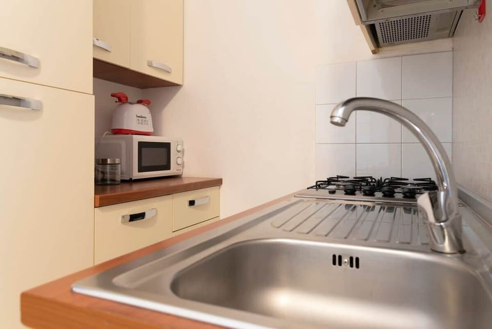 Angolo cucina completo di Piano cottura con 4 fuochi, Figorifero con scomparto Freezer, Microonde, macchina da caffe con cialde di cortesia e Tostapane