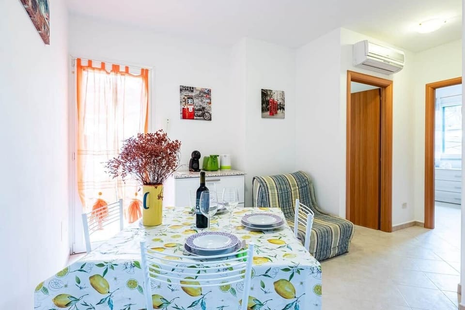 Zona giorno luminosa e accogliente, caratterizzata da ampie finestre che inondano l’ambiente di luce naturale e offrono un accesso diretto al giardino privato. Lo spazio include un pratico divano letto, ideale per ospitare comodamente una persona.