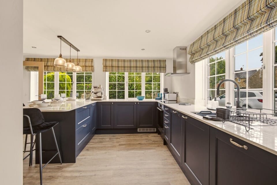 Contemporary kitchen with navy cabinetry, quartz worktops and breakfast bar