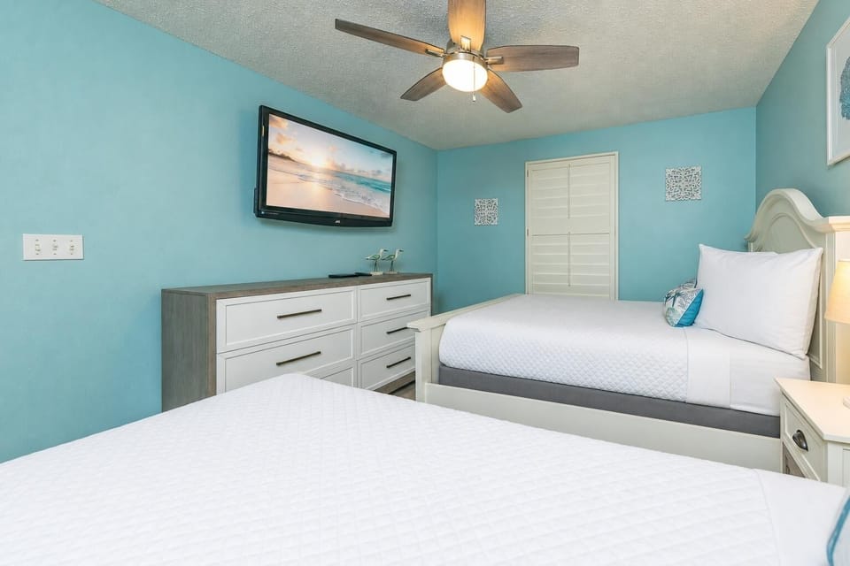 Blue walls surround the guest suite with two beds inviting restful sleep after a busy day