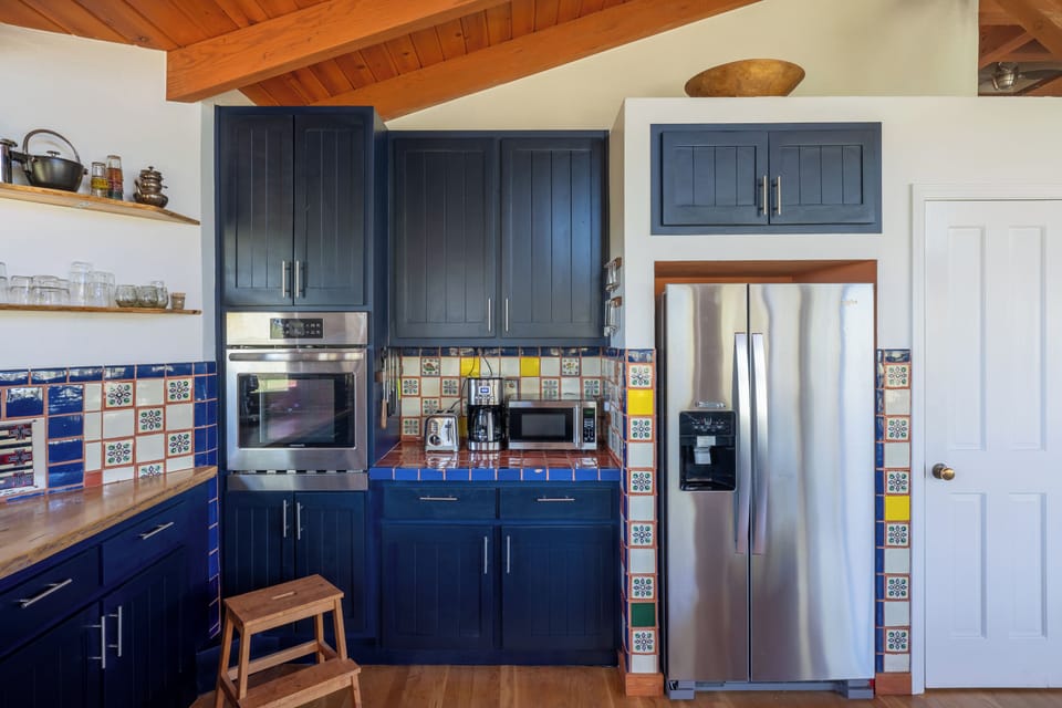 Your fully equipped kitchen features vibrant tile work, modern stainless-steel appliances, and warm wood accents creating a welcoming space to prepare home-cooked meals during your stay.