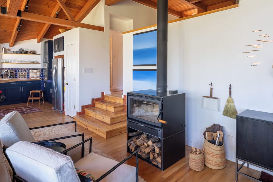 Relax in your open-concept living space where modern comforts meet rustic charm. The warmth of the wood-burning fireplace and stunning timber-beam ceiling create your perfect mountain retreat.