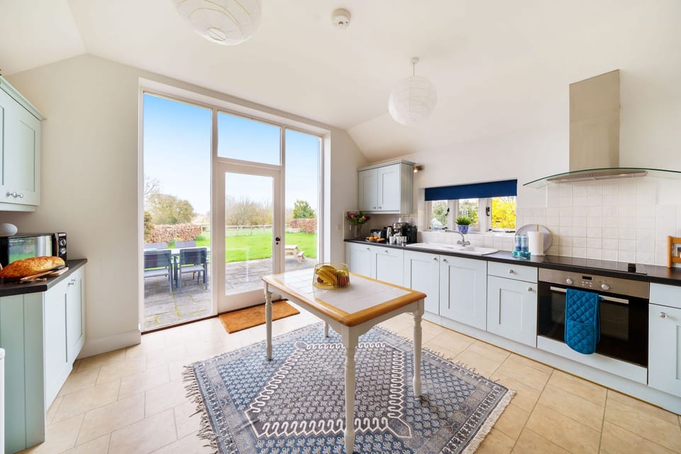 Byre House, Sutton Waldron, Shaftesbury: The light-filled kitchen with door leading out to the garden patio