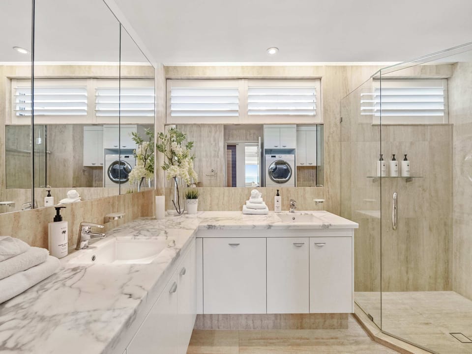 The shared bathroom, twin marble vanity and a walk-in shower.