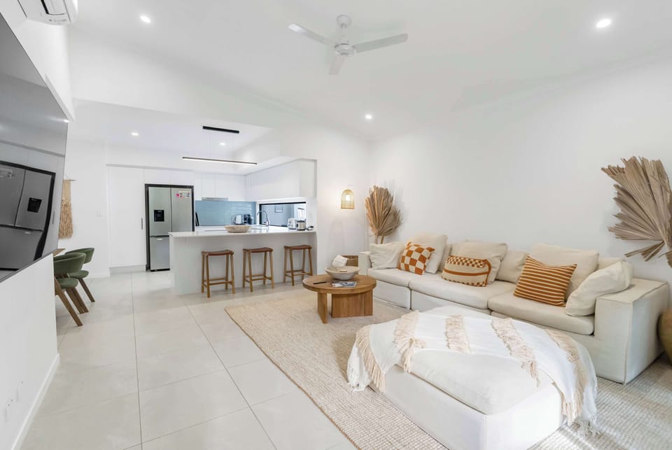 The living room's open-plan layout creates an inviting space where everyone can come together, with seamless flow between the lounge, kitchen, and dining area.
